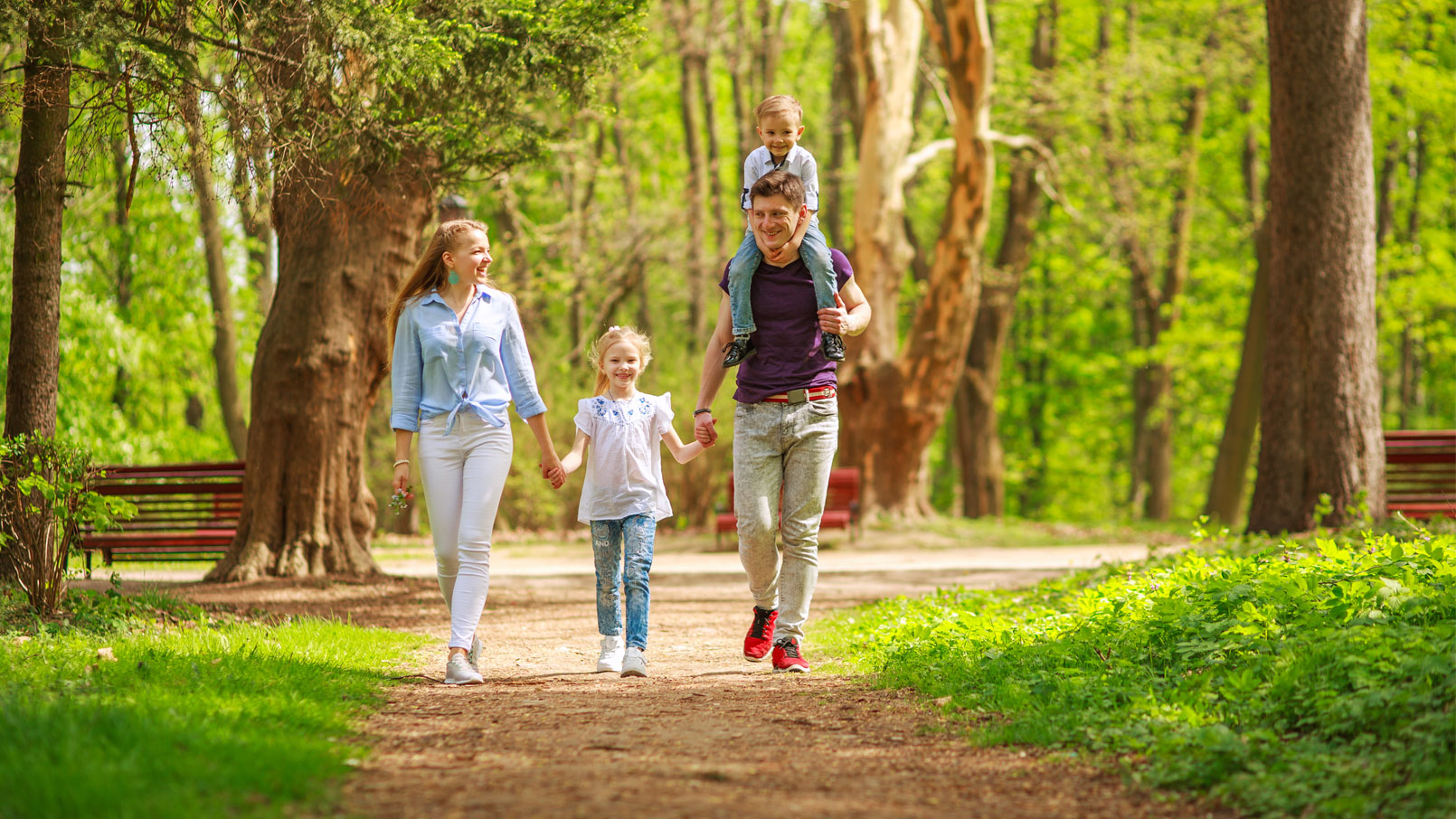 Uśmiechnięte rodzina spaceruje w parku, w pobliżu osiedla Bliski Olechów